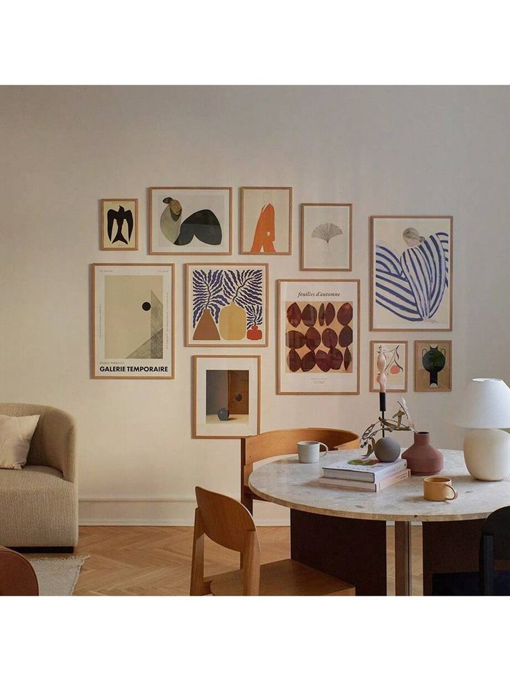 a living room filled with furniture and pictures on the wall above a table in front of a couch