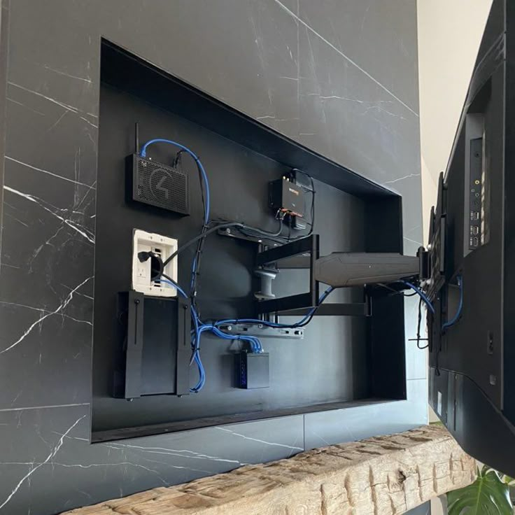 a wall mounted tv sitting on top of a wooden shelf