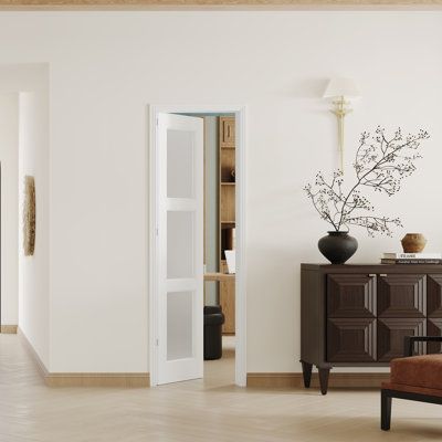 a living room filled with furniture and a vase on top of a dresser next to a doorway