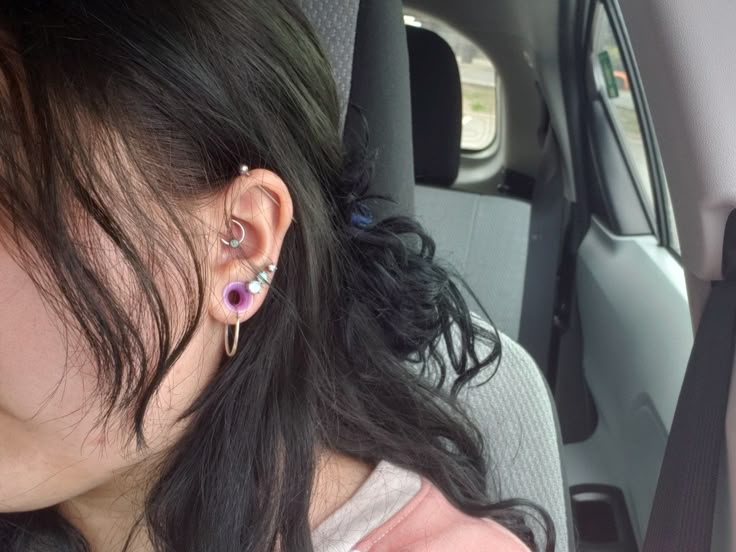 a woman with ear piercings sitting in a car