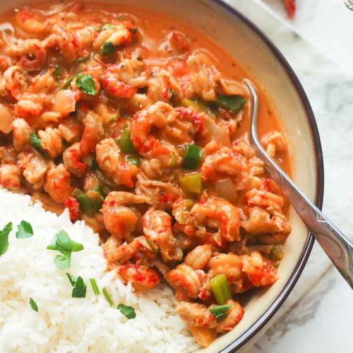 a bowl filled with rice, meat and veggies next to a spoon in it