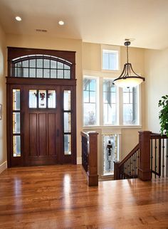 an entryway with wooden floors and windows