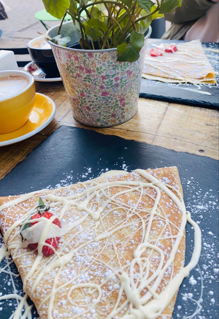 It’s a picture of a crêpe pancake on a black plate with a strawberry and white chocolate stripped over it beside  the  crêpe to the left it has a yellow cup of chai latte Yummy Crepes, Best Crib, Chocolate Blanco, Food Tasting, Good Healthy Recipes, Food Coloring, Crepes, Small Shop, White Chocolate