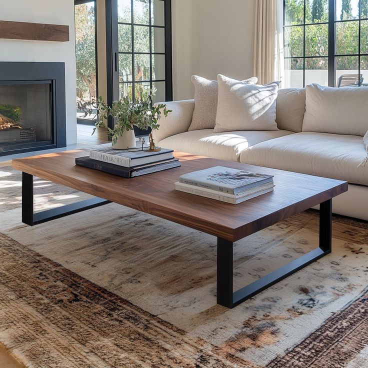 a living room with a couch, coffee table and fire place in front of a window