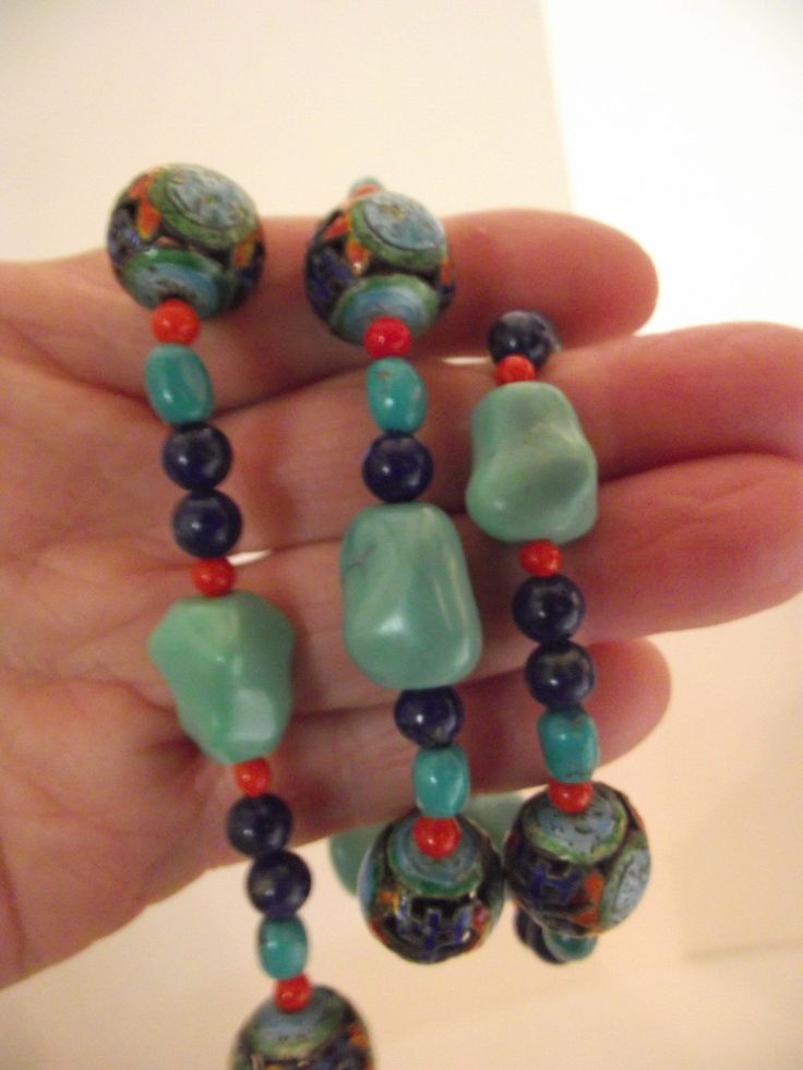 note: see my shop for more listings like this :) https://beadbarista.etsy.com Vintage Chinese Pierced Cloisonné Shou Necklace w/ Knuckle Turquoise, Coral and Lapis beads This is a lightweight necklace that is comfortable to wear all day long. The turquoise knuckle (nugget) beads are a dreamy aqua blue that feel so smooth when you rub them with your fingers... almost like worry beads, they are soothing to touch. The small coral and lapis beads accent the vivid cloisonné shou beads.  The seven clo Handmade Artisan Turquoise Beads, Handmade Turquoise Jade Jewelry, Turquoise Large Beads Gems And Cabochons For Jewelry Making, Large Turquoise Beads For Jewelry Making, Turquoise Large Beads For Jewelry Making, Handmade Turquoise Jade Beaded Necklaces, Handmade Turquoise Czech Glass Beaded Necklaces, Unique Handmade Turquoise Beads, Gems And Cabochons, Unique Green Turquoise Necklace With Large Beads