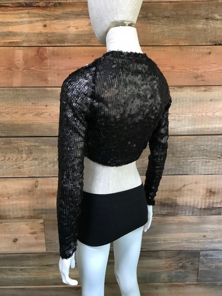 "This shrug is perfect for upcoming holiday parties, as well as any night out that you deserve a little sparkle. It's a great piece to thrown on over a cocktail dress or even a tee and jeans for style, and for a bit more coverage. This most recent cut shapes elegantly around the ribcage and hits a length in the middle of the back. Sizes: S (4-6 women's US size), M (6-8 women's US size) -Fabric content: sequin mesh. Spot clean & Dry clean only. -Feel free to message with any questions or cust Winter Evening Cropped Tops, Fitted Winter Crop Top For Evening, Cropped Tops For Evening Wear In Fall, Long Sleeve Crop Top For Evening In Fall, Glamorous Stretch Embellished Crop Top, Glamorous Embellished Stretch Crop Top, Evening Sequined Crop Top, Evening Sequin Crop Top, Black Fitted Cropped Shrug