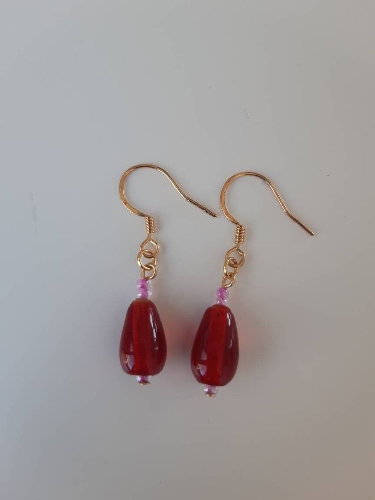 Drop length earrings featuring red glass beads with pink seed beads. Gold-coloured fittings. Drop length measurement is the whole length including the ear wire.  Pretty earrings for any occasion. Pink Bead Earrings, Red Czech Glass Beaded Earrings With Dangling Beads, Red Beaded Teardrop Dangle Earrings, Red Teardrop Earrings With Dangling Beads, Red Long Drop Beaded Earrings As Gift, Red Long Drop Beaded Earrings For Gift, Red Beaded Czech Glass Earrings, Red Teardrop Beaded Dangling Earrings, Red Teardrop Beaded Earrings With Dangling Beads