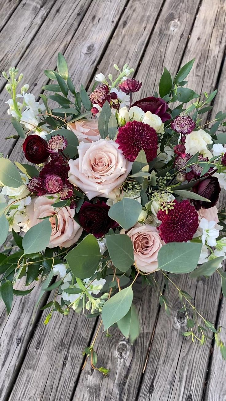 a bouquet of flowers sitting on top of a wooden table