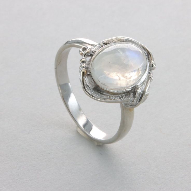 This is a beautiful Rainbow Moonstone Ring in 925 Sterling Silver with a Rhodium finish.  The silver does also not include any nickel or other substances causing most allergies. The ring is thus hypoallergenic. Rhodium makes the silver less tarnish. Size of the Moonstone 1.1 x 0.8 cm 0.43 x 0.31 inch Please note: Our jewelry is photographed close up to show detail and may appear larger than they are. We use a dime coin as size reference on one of the pictures. Usually we ship on the same day we receive the payment for the order. You will receive the item in a gift box - perfect to surprise someone or yourself. We want you to be happy with your purchase. If you do not like what you bough can send it back and we will refund you the money. Please do not hesitate to contact us so we can solve Sterling Silver Oval Cabochon Moonstone Ring, Silver Moonstone Crystal Ring In Moon Shape, Oval Silver Moonstone Gemstones, Oval Cabochon Moonstone Ring In Sterling Silver, Elegant Silver Moonstone Birthstone Ring, White Birthstone Ring In Moon Shape, White Moon Shaped Ring With Birthstone, White Moon-shaped Birthstone Rings, Silver Sterling Silver Moon-shaped Opal Ring