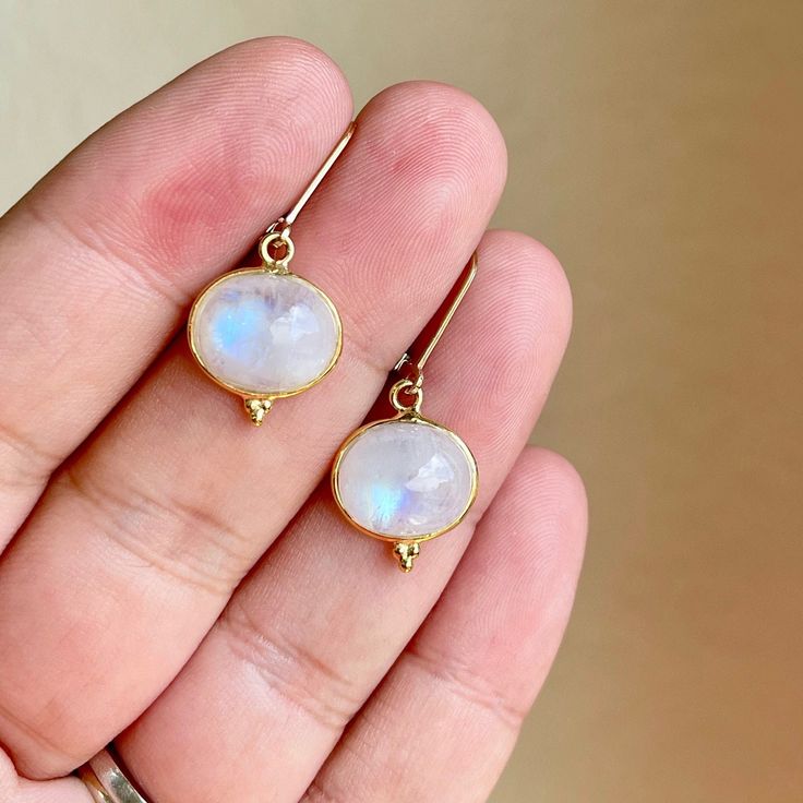 Rainbow Moonstone Earrings, June Birthstone, Blue Flash White Moonstone Smooth Oval Earrings in Gold or Silver, Statement Gift for women These absolutely breathtaking earrings feature blue flash Rainbow Moonstone smooth ovals bezeled in your choice of 14k gold filled or sterling silver. These are premium quality, very eye catching. The white ovals are suspended from lever back ear wires. These are classic, timeless earrings but very plain and simple which makes the suitable for every day wear an White Oval Moonstone Earrings, Oval Moonstone Earrings For Gift, Handmade Oval Moonstone Earrings, Timeless Earrings, Oval Earrings, White Moonstone, Oval Earring, Moonstone Earrings, Earrings In Gold