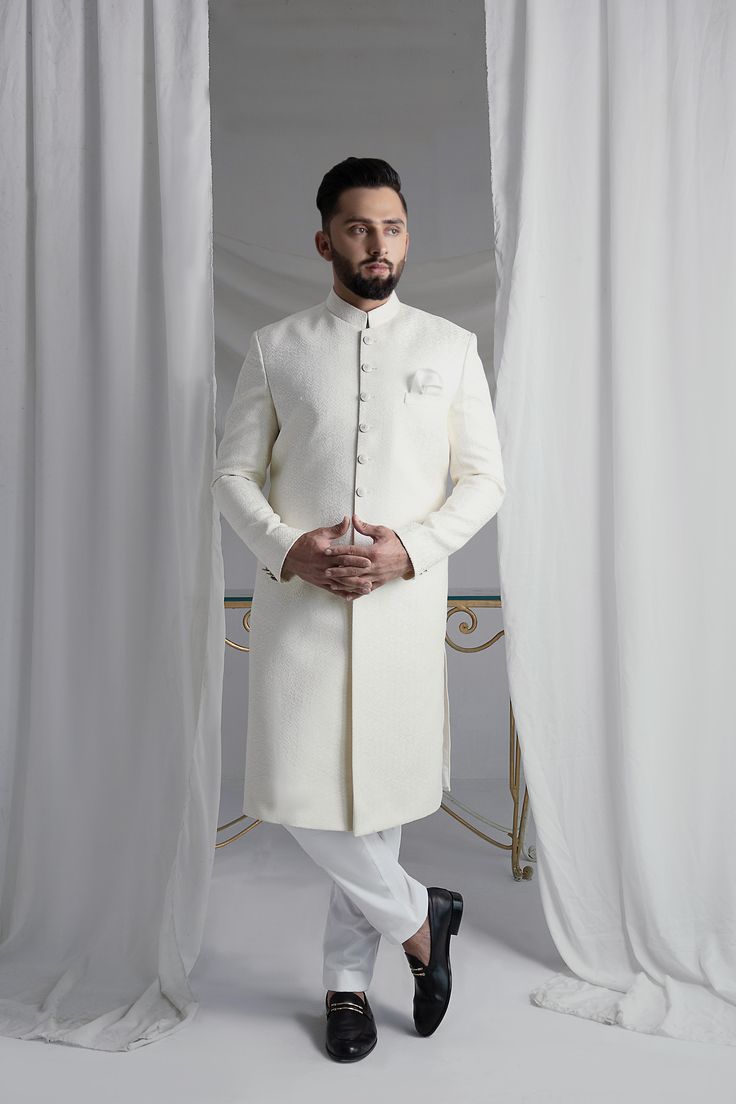 This White Long Sherwani is a stunning choice for your special occasion. Made from printed off-white khaadi silk, it features a silk kurta and cotton pajama for a comfortable fit. Complete your look with the elegant organza Rajastjhani kula (turban) and exude an air of style and sophistication. Wedding Silk Sherwani For Eid, Designer White Lawn Suit With Naqshi, Elegant Raw Silk Sherwani Straight Kurta, Elegant Sherwani In Raw Silk With Straight Kurta, Elegant Raw Silk Nehru Jacket With Naqshi, Elegant Silk Sherwani For Eid, Elegant Cotton Silk Sherwani For Festive Season, Elegant Festive Cotton Silk Sherwani, Elegant Cotton Silk Sherwani For Diwali