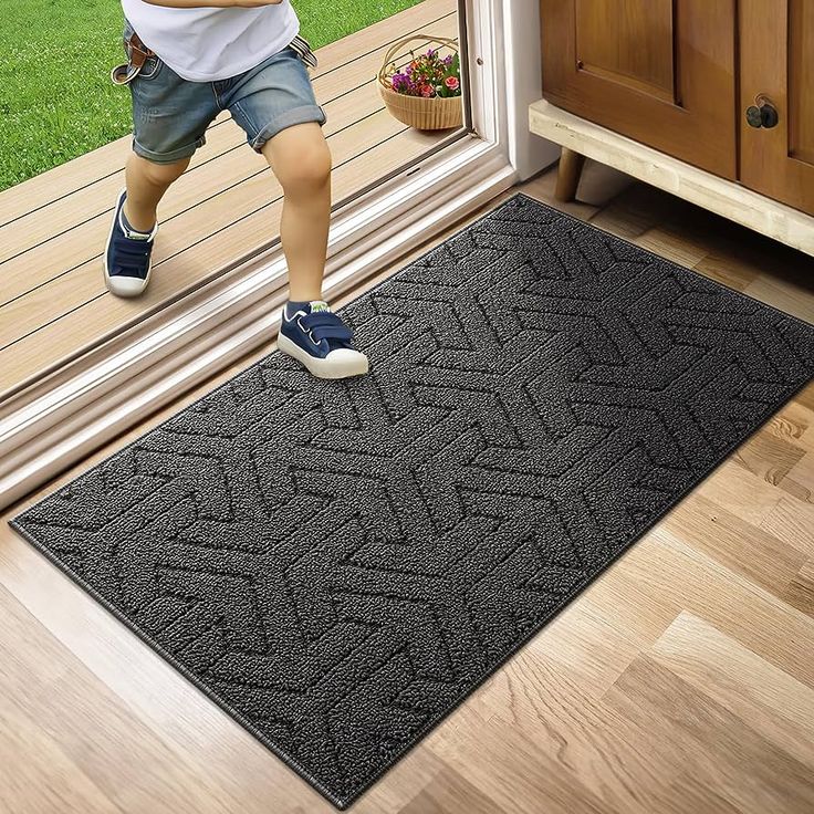 a child is standing on the door mat