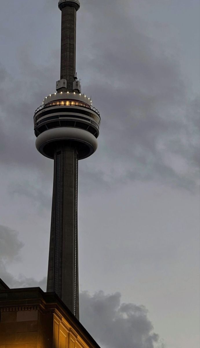 a tall tower with a clock on it's side under a dark cloudy sky