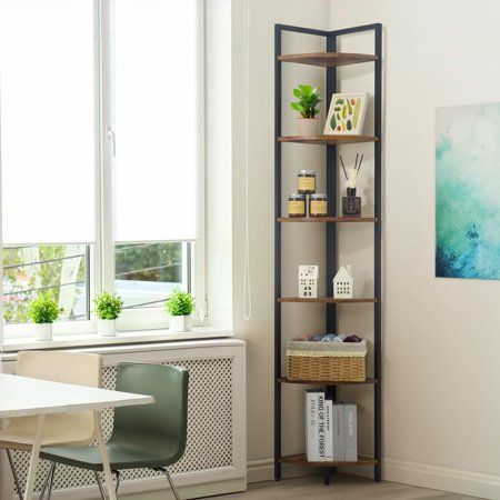 a room with a table, chair and bookshelf in front of a window