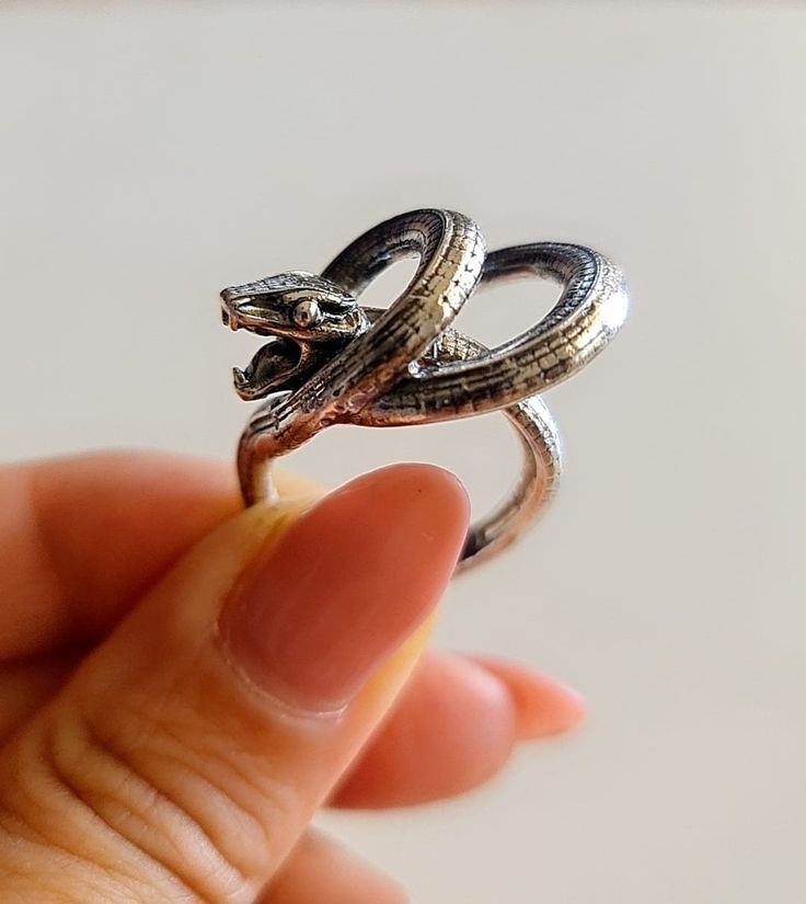 Introducing our stunning Sterling Silver Snake Ring, handcrafted with the utmost attention to detail. This exquisite piece captures the essence of the mystical serpent and is bound to add a touch of enchantment to any outfit.  Crafted in Cyprus, this beautiful ring is made from high-quality sterling silver, ensuring durability and longevity. The intricate design of the snake is sure to impress and make a statement wherever you go.  Highlights:  - Handmade item crafted by expert artisans in Cyprus.  - Made using high-quality Sterling Silver 925.  Benefits:  - Exquisite and unique design that adds character to any outfit.  - Made from durable materials for long-lasting use.  - Perfect for both casual and formal occasions.  Usage:  This Sterling Silver Snake Ring is versatile and can be match Ouroboros Ring, Silver Snake Ring, Serpent Jewelry, Open Heart Ring, Handmade Skulls, Serpent Ring, Dog Ring, Snake Ring Silver, Ring Elegant