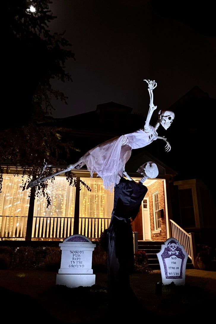 a man and woman standing next to each other in front of a house at night