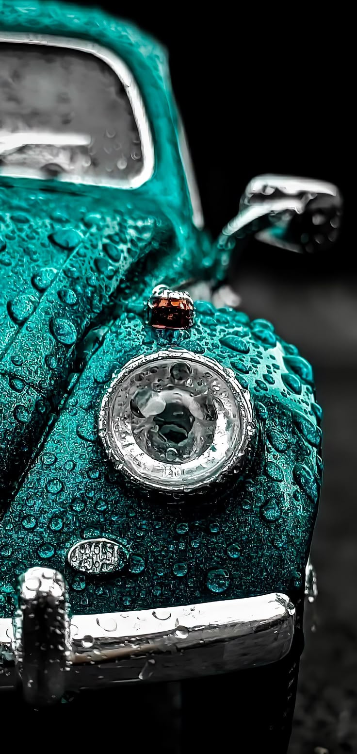 an old green car with water drops on it