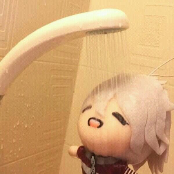 a stuffed doll hanging from the side of a shower head