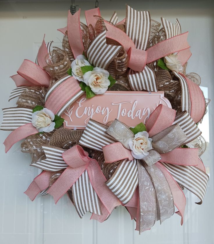 a pink and brown wreath with flowers on the front door