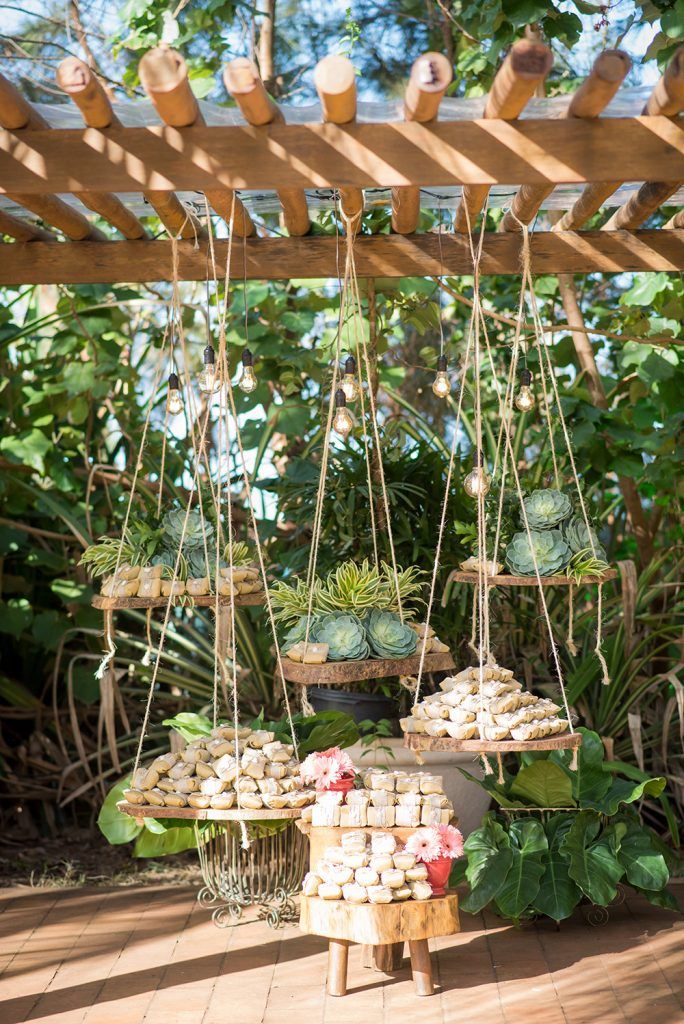 an assortment of food is displayed under a wooden pergolated structure in the garden