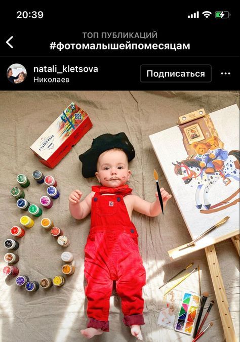 a baby is laying on the ground with art supplies