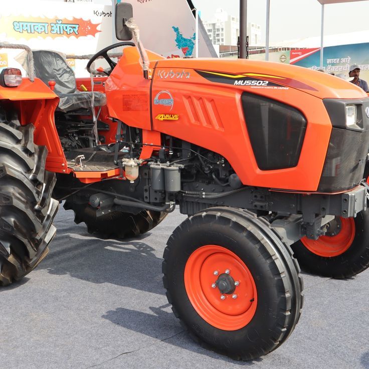 an orange tractor parked on top of a parking lot