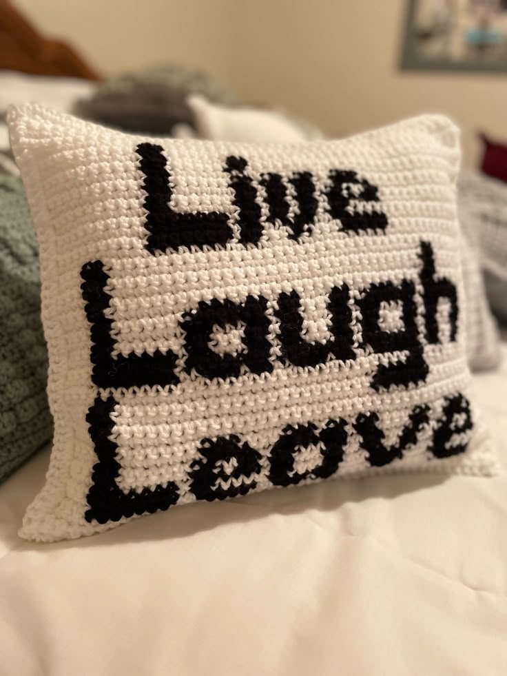 a crocheted pillow that says live laugh love