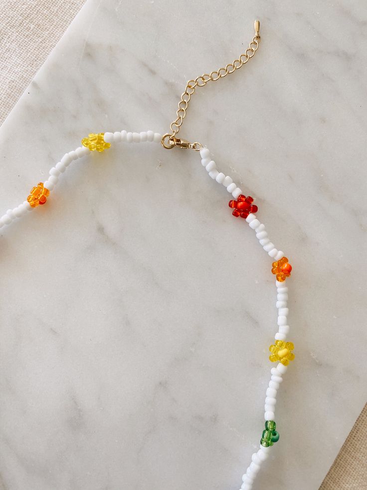 "This hand beaded flower necklace features rainbow or pastel flowers and measures 16\" at its smallest. Necklace is adjustable up to 18\" I love this necklace layered with other gold chains or worn alone to spruce up jeans and a t-shirt. Strung on elastic jewelry string and has a gold plated lobster clasp closure. Message me with any questions!" Adjustable Beaded Necklace With Colorful Beads And Flower Pendant, Adjustable Flower Necklace With Round Beads For Spring, Trendy Adjustable Beaded Flower Necklace, Trendy Adjustable Flower Necklace With Colorful Beads, Colorful Beads Adjustable Necklaces For Spring, Adjustable Tiny Beads Necklace For Spring, Rainbow Jewelry With Colorful Beads For Spring, Spring Adjustable Tiny Beads Necklace, Multicolor Adjustable Beaded Necklaces With Flower Pendant