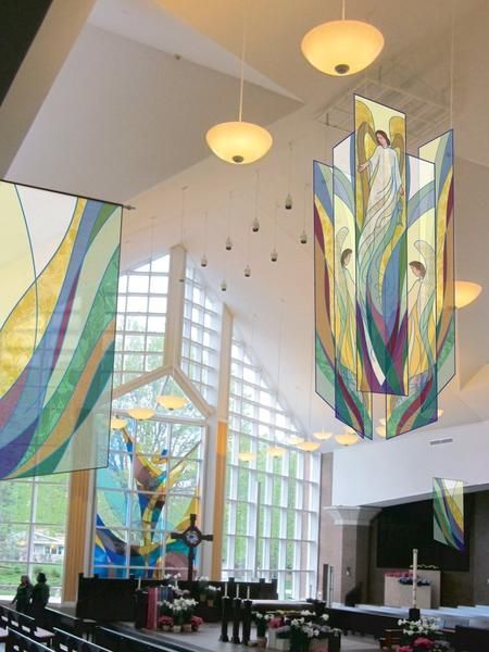 the interior of a church with stained glass windows and pews in front of them