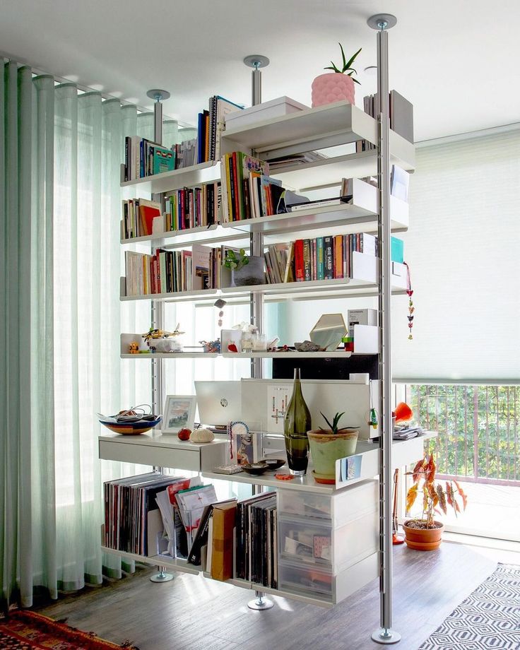 a living room filled with furniture and bookshelves next to a sliding glass door