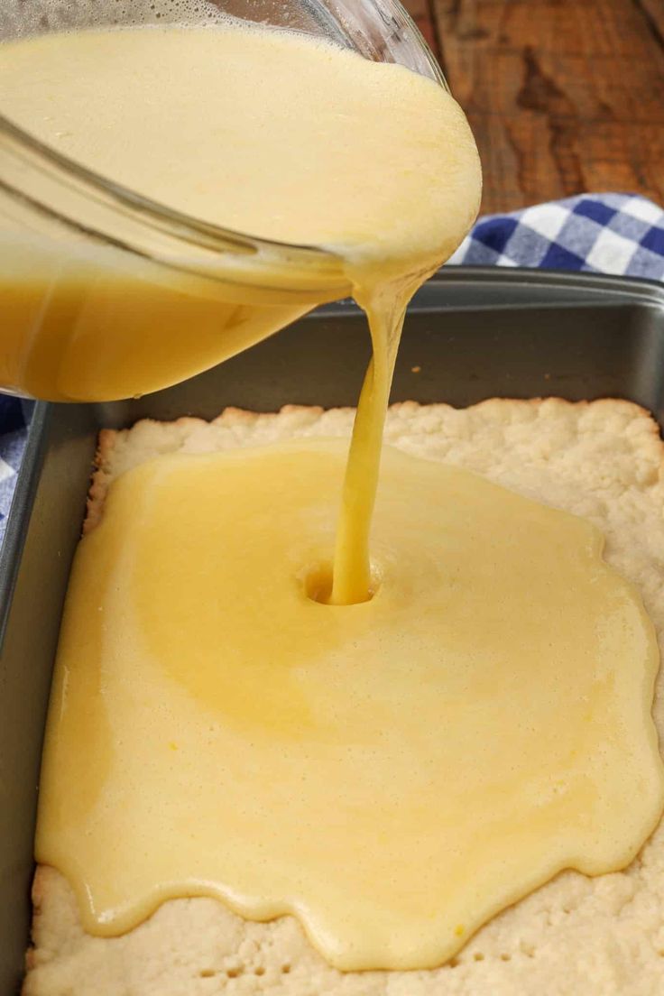 a person pouring batter on top of a piece of bread