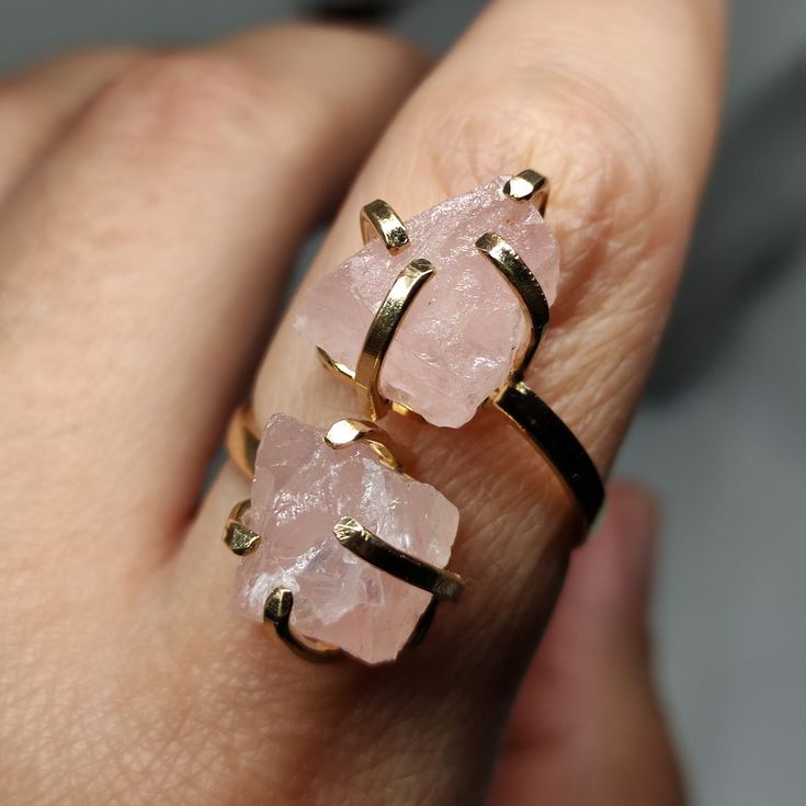 Elevate your style and gift love with our Raw Rose Quartz Ring. This exquisite piece showcases the gentle beauty of rose quartz, known for its soft pink hues and heartwarming energy. It's not just a statement piece; it's a heartfelt gift that captures the essence of affection and elegance. 🔸Adjustable band ring 🔸10 mm each stone size 🔸Color may vary according to lighting 🔸Gold filled We offer  🔸Fast shipping ( under normal conditions) 🔸Free shipping  🔸Polishing cloth ( to keep your piece shiny) 🔸Jewelry case on orders of 100€ 🔸Gift box 🎁 🔸Great customer service                                  Rose quartz is cherished for its association with love and positivity. It's believed to enhance emotional well-being and open the heart. Its gentle pink tones make it a timeless choice for Fine Jewelry Crystal Ring With Natural Stones As Gift, Dainty Rings With Natural Stones For Gift, Dainty Rings With Natural Stones As Gifts, Dainty Crystal Ring With Natural Stones As Gift, Rose Gold Spiritual Rings For Gift, Round Quartz Jewelry Gift, Quartz Jewelry As A Gift, Quartz Jewelry Gift, Adjustable Rose Quartz Rose Gold Ring