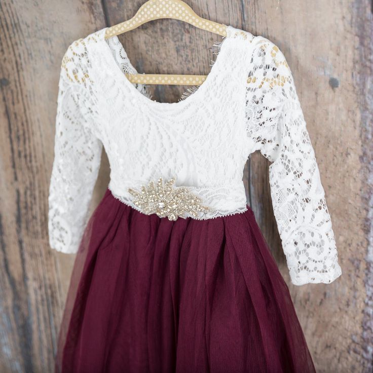 "This dress is just beautiful! It includes a delicate white lace bodice with a deep maroon/burgundy/wine colored skirt. The V Back with unfinished lace adds the perfect amount of boho chic look to this amazing dress. The lace sleeves are finished with the perfect amount of detail. It also includes a rhinestone belt sash that is removable. Perfect for your next special event. We also offer this style in the following colors: Blush Pink: https://www.etsy.com/listing/785978849/white-lace-flower-gir Burgundy Ball Gown, Merlot Dress, Long Sleeve Wedding Gown, Burgundy Flower Girl Dress, Tulle Long Dress, Lace Flower Girl Dress, Long Sleeve Wedding Gowns, Maroon Wedding, Tulle Wedding Gown