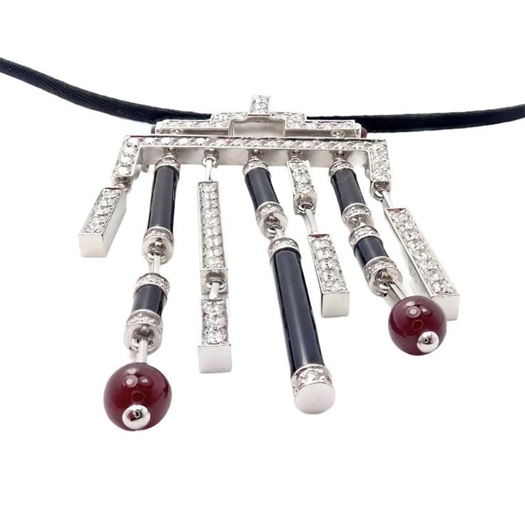 Metal: 18k White Gold  Measurements: Length silk cord: 17.25''  Pendant: 33mm x 62mm  Weight: 24.5 grams  Stones: 153 round brilliant diamonds, E color, VVS1 clarity total weigh approximately 3ct. Also with 6 onyx stones, and 2 ruby beads 6mm each.  Hallmarks: Cartier 750 (serial number omitted) French Hallmarks   Please read description for most accurate dimensions and use QA to inquire on any additional details. Cartier Black Evening Jewelry, Cartier Luxury Gemstone Jewelry, Luxury Cartier Gemstone Jewelry, Cartier Gemstone Jewelry For Gifts, Ruby Diamond Necklace, Black Tears, Vintage Designer Jewelry, Ruby Beads, Silk Cord