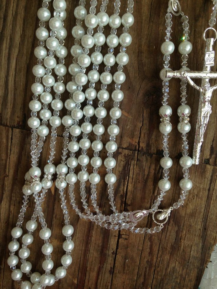 "Imported Crystal Pearls 10mm, pure white and and finished with diamond cut crystals., accented with rhinestone rhondelles ad silver plated bead caps. This is a wedding rosary: two complete Rosaries joint by beautiful center piece, intended for religious ceremonies, Measurements: each loop is 45\" around and the lasso is 41\" long from top to bottom. The crucifix is 4\" tall and 2.5\"wide...the lasso can be made larger upon request. Hablamos español , Si tiene preguntas con gusto le atenderemos Elegant Pearl Beaded Rosary, Elegant Pearl White Pearl Rosary, Elegant Pearl Rosary For First Communion, Elegant Beaded Wedding Rosary, Elegant Pearl Rosary With 8mm Beads, Elegant Pearl Rosary With Round Beads, Silver Wedding Rosary With 8mm Beads, Silver Wedding Rosary With Round Beads, Wedding Silver Pearl Rosary