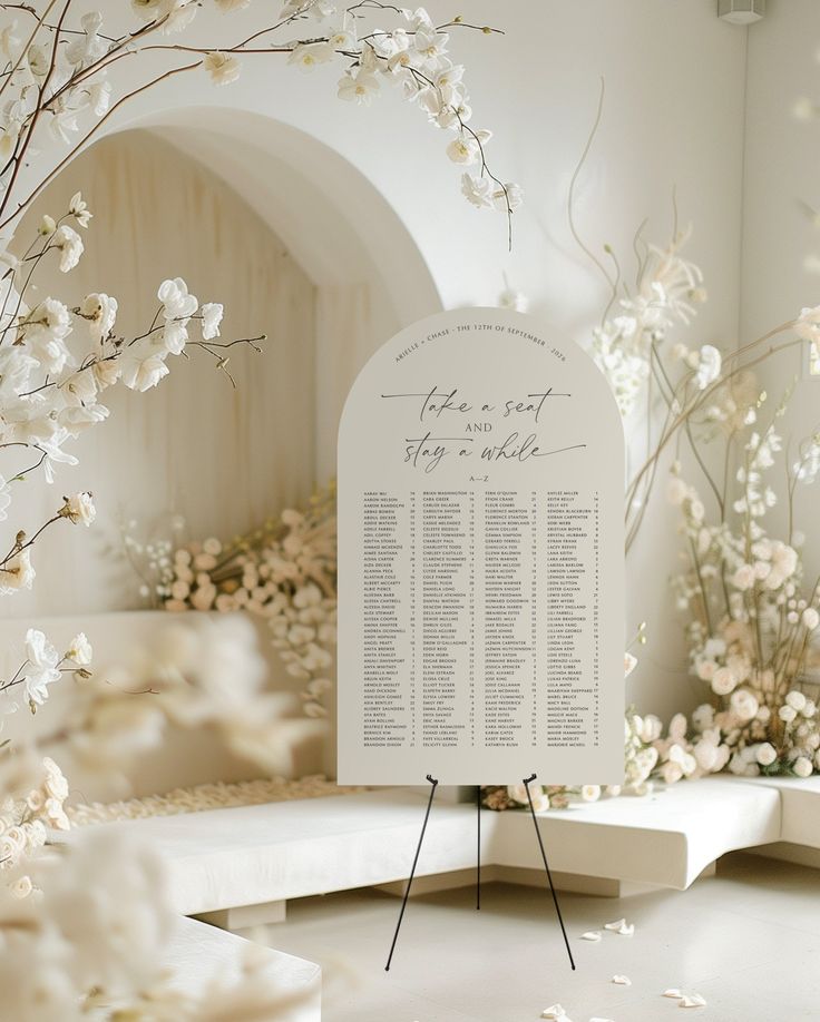 a seating chart with white flowers in the background