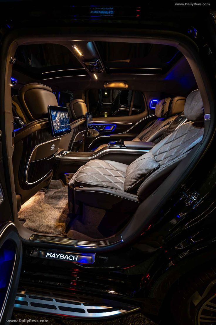 the interior of a luxury car is lit up with blue lights