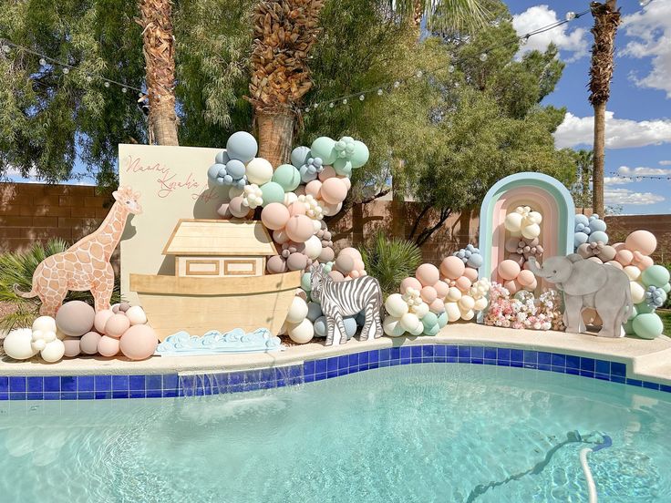 a pool decorated with balloons and giraffes