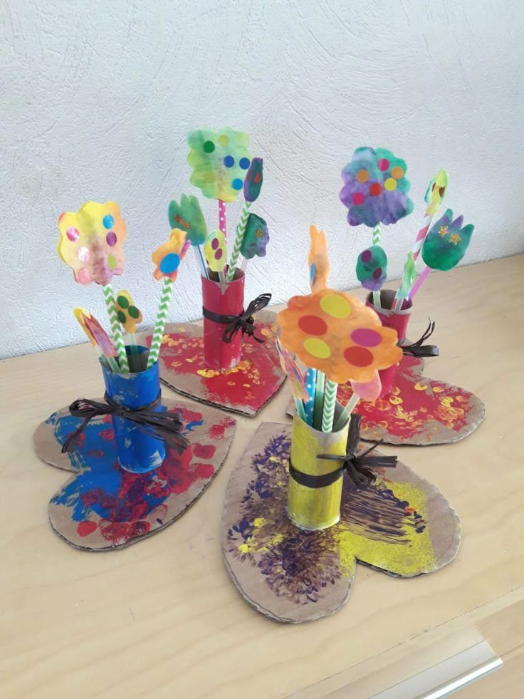 three vases filled with colorful flowers on top of a wooden table