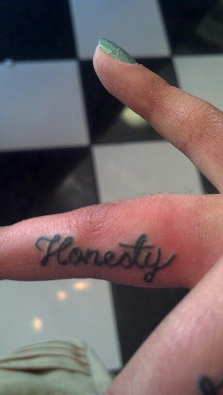 a person's finger with the word honesty written on it