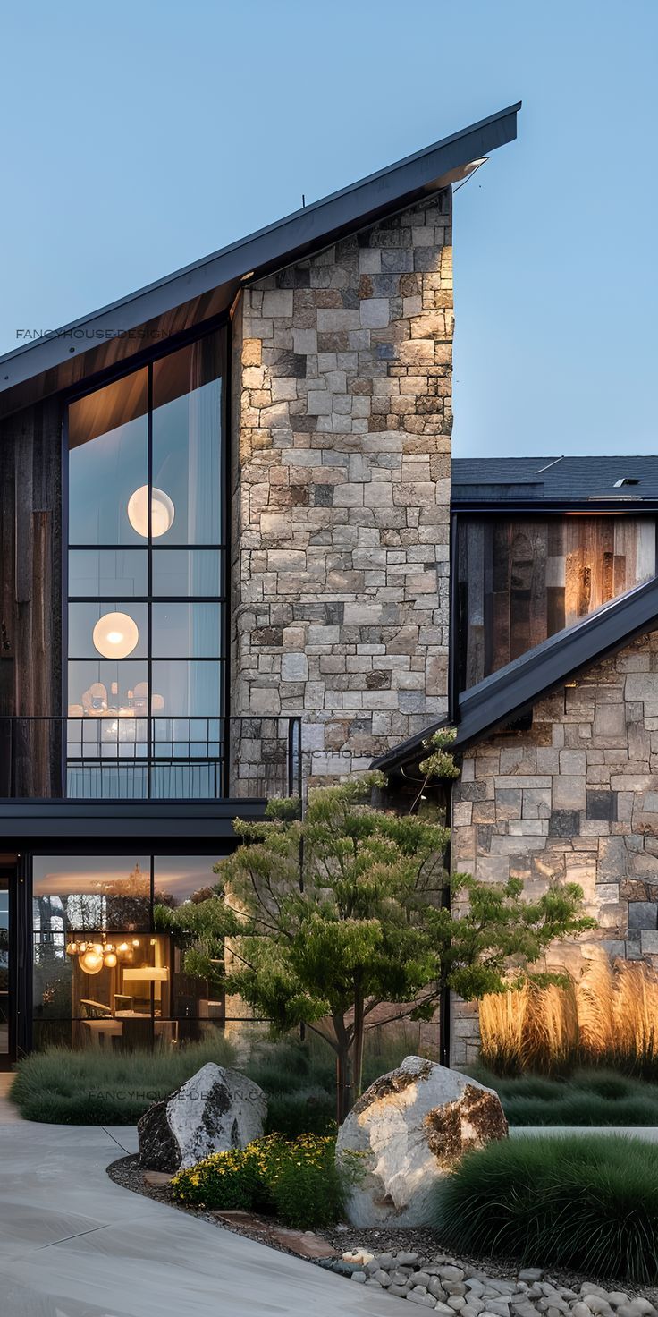 a modern house with large windows and stone walls