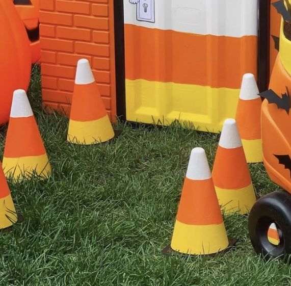 some orange and white cones are in the grass