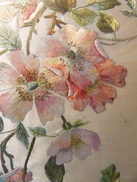 an embroidered fabric with flowers and leaves on it