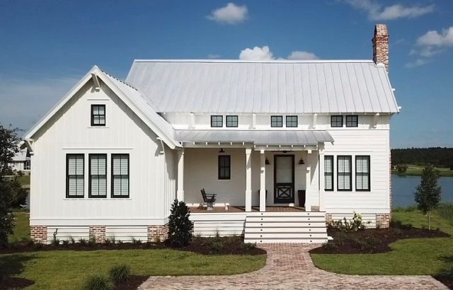 a white house sitting on top of a lush green field