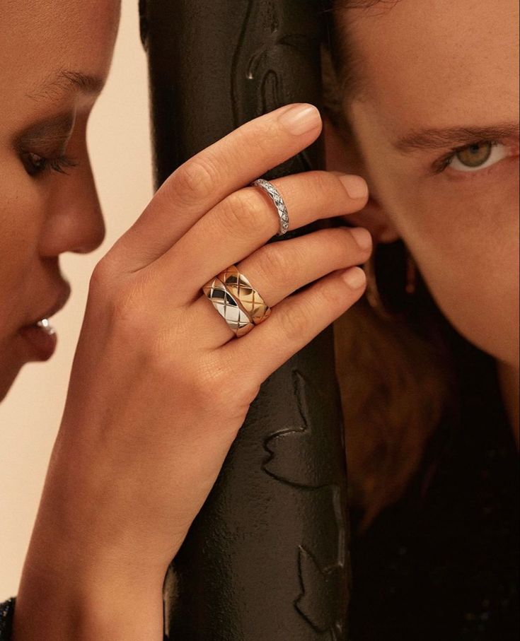 two women looking at each other with rings on their fingers