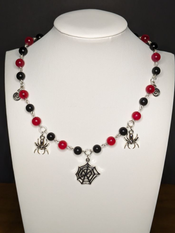 a necklace with black and red beads on a white mannequin