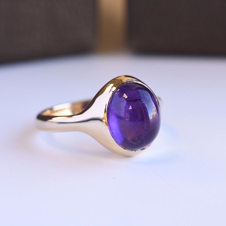 Natural amethyst with hidden heart Metal: 14K Yellow Gold Stone: Amethyst Stone Size: 10mm x 8mm Stone Shape: Oval Semi Hollow Dimension: 3mm shank Classic 14k Gold Purple Amethyst Ring, Timeless Oval Purple Amethyst Ring, Timeless Amethyst Ring For Anniversary, Timeless Purple Oval Amethyst Ring, Timeless Amethyst Anniversary Ring, Classic Purple Gemstone Signet Ring, 14k Gold Polished Amethyst Ring, 14k Gold Amethyst Ring With Polished Finish, Luxury Amethyst Cabochon Ring