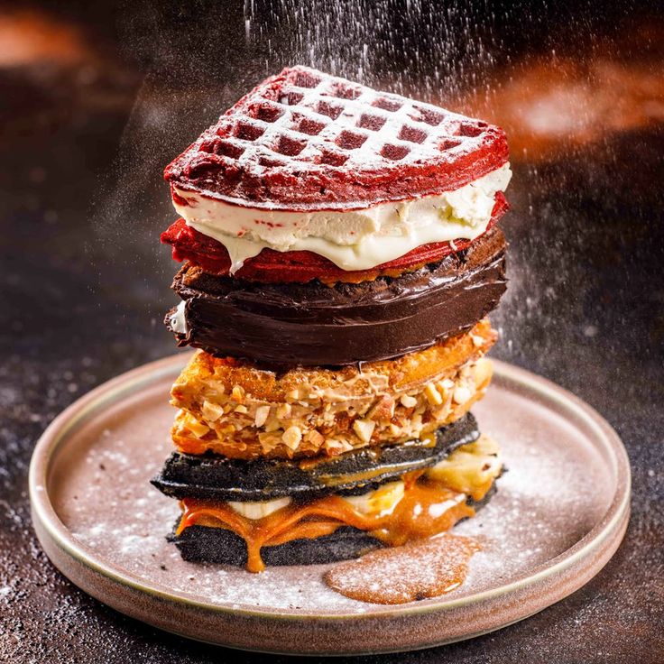 a stack of waffles sitting on top of a plate covered in ice cream