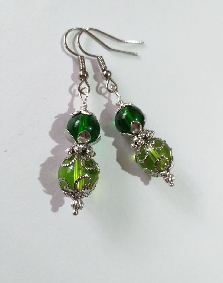 Victorian silver earrings green earrings filigree earrings Antique style silver Boho Earrings Bohemian silver green earrings gift for her Bohemian silver green filigree earrings . Antique style earrings . Silver tone beautiful Boho earrings . Bohemian earrings . Victorian style silver-tone green glass beads earrings .  Modern earrings . Chic silver toned green earrings .  Absolutely beautiful earrings ! FREE SHIPPING  Material : silver tone metal filigree beads, steel, green glass beads, Length with hooks : 2.15 ( 5.5 cm) If you have any question, please contact me ! Thank you for visiting my shop ! If you have a RUSH ORDER and you want to pay for FAST SHIPPING by DHL - 3-5 business days is HERE :  https://www.etsy.com/listing/914808240/update-fast-shipping-gift?ga_search_query=fast&ref=sh Elegant Light Green Earrings As Gift, Elegant Light Green Earrings For Gift, Elegant Green Sterling Silver Earrings, Elegant Light Green Drop Earrings, Traditional Green Filigree Jewelry, Nickel Free Green Metal Earrings, Green Metal Earrings For Gift, Handmade Lime Green Dangle Earrings, Green Sterling Silver Dangle Jewelry