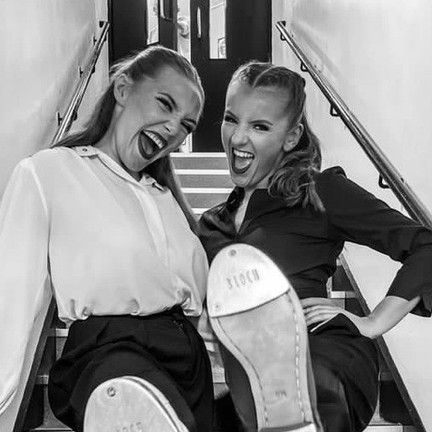 two women sitting on the stairs with their feet up